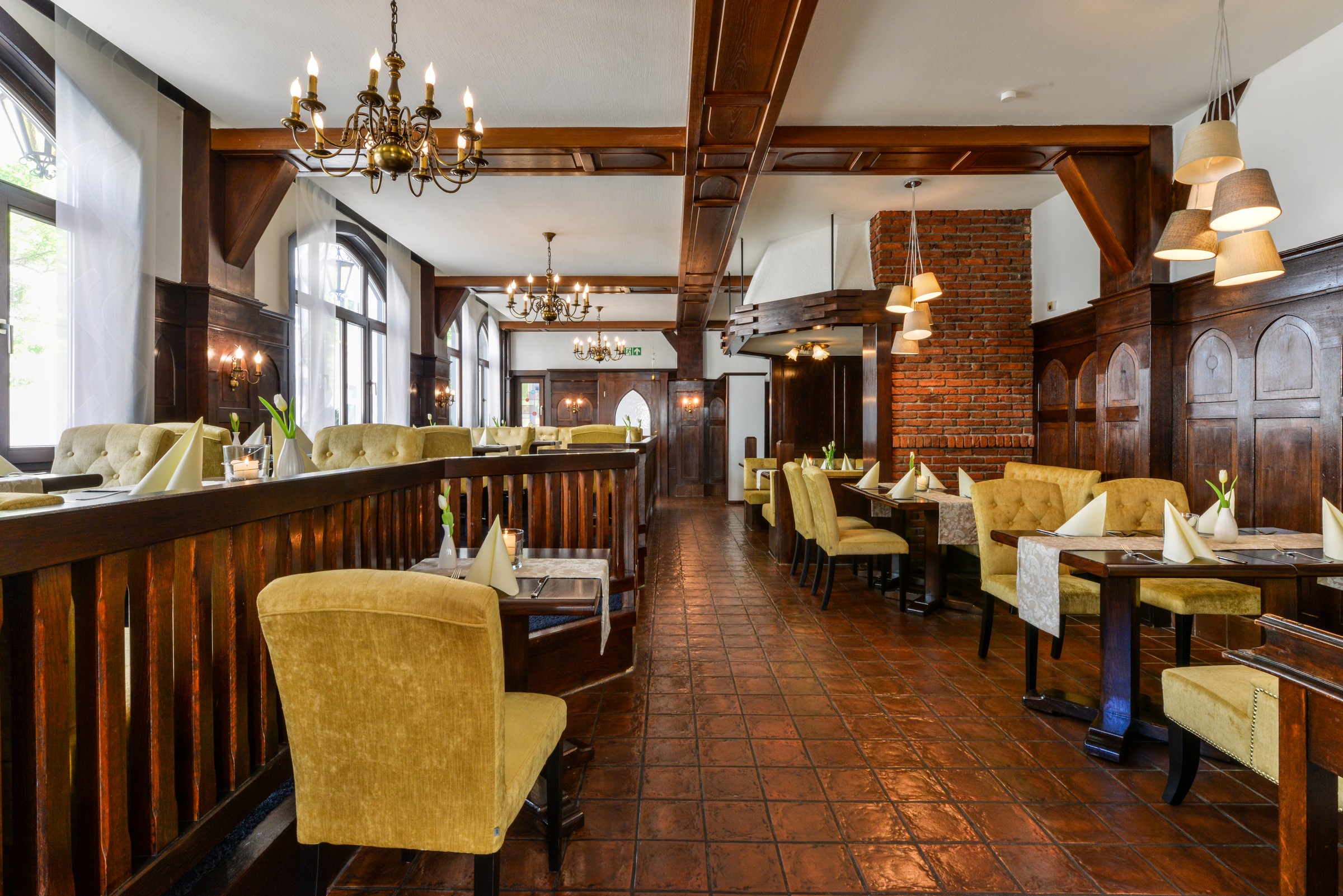 Karl’s Esszimmer with wood paneling, gold-coloured armchairs and set tables