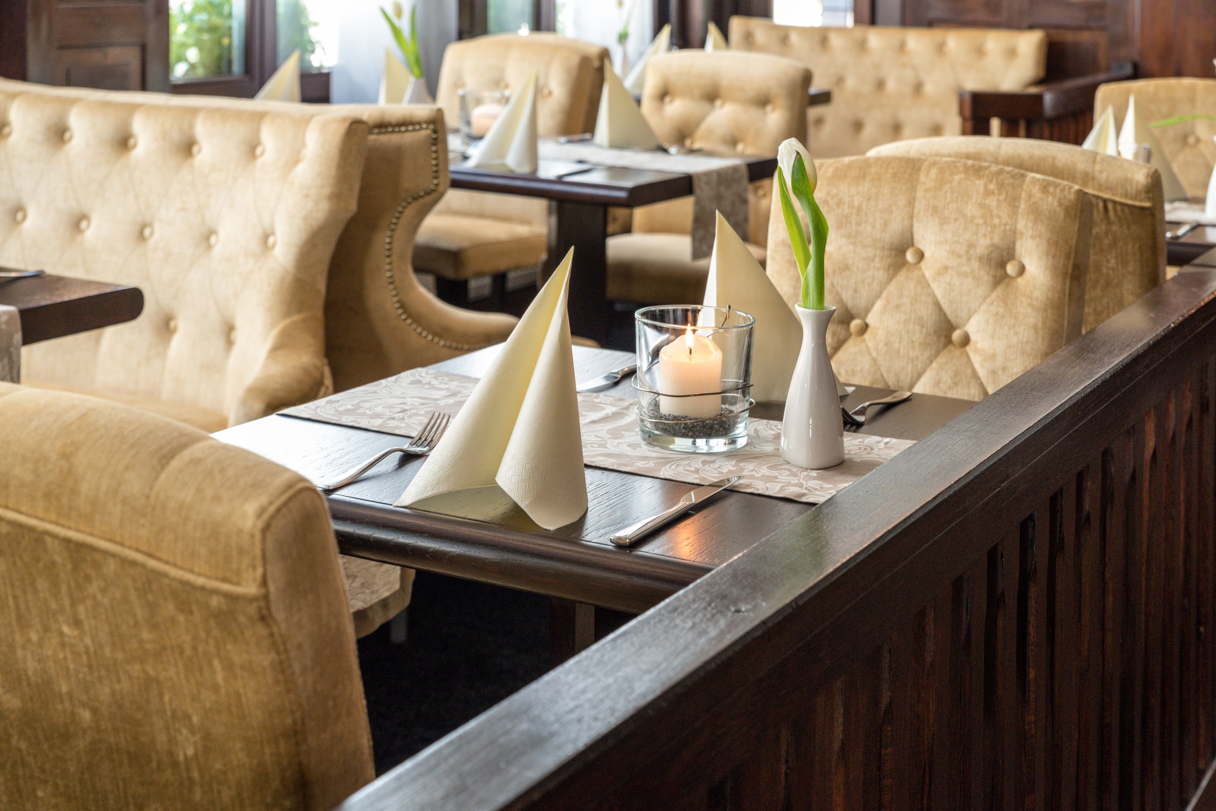 A set table with candle and white tulip in Karl’s Esszimmer