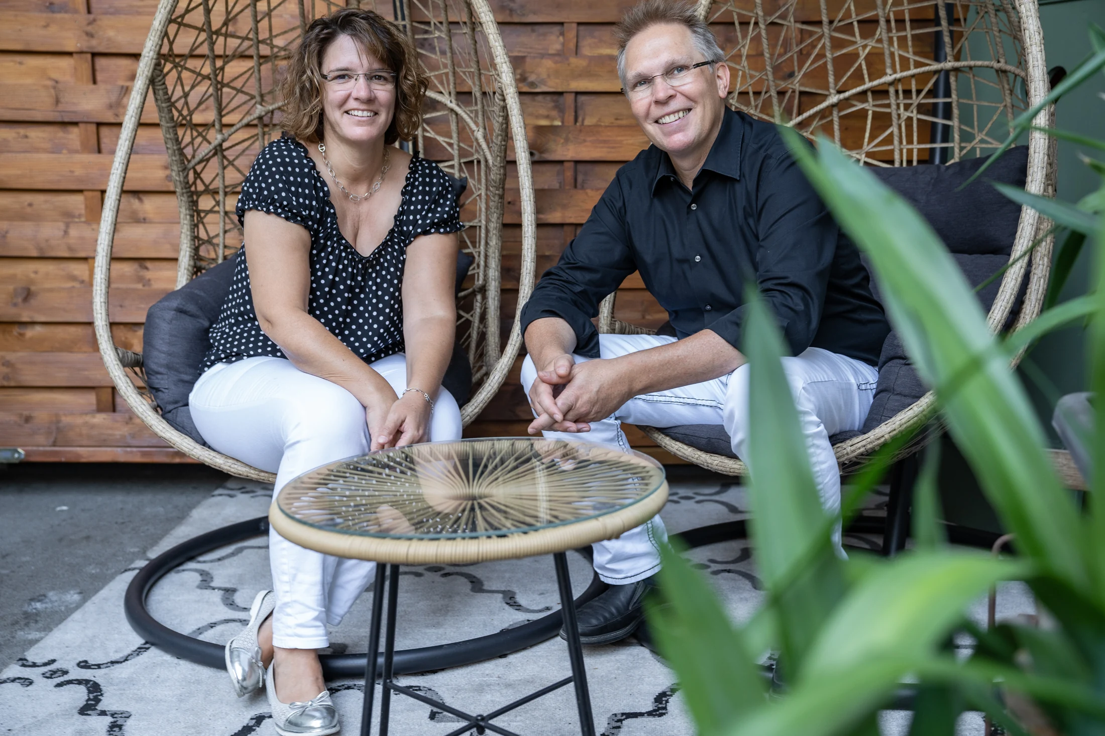 The hosts of the Vier Jahreszeiten sit in hanging chairs in the inner courtyard